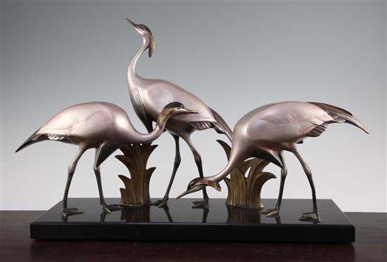 Armand Sinko. A French Art Deco patinated and cold painted bronze figure group of three cranes, 18.5in.